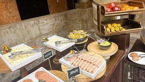 A buffet with labeled food options including 'Outos', 'Jamón', and 'fruits'. - AYNI BOUTIQUE HOTEL  (Cusco)