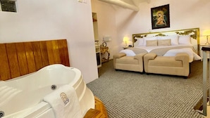 A spacious bedroom with a large bed, a separate sofa, a bathtub, and a chandelier. - AYNI BOUTIQUE HOTEL  (Cusco)