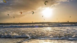 A beach scene with waves and multiple kitesurfers. - Résidence Hôtelière de l Estuaire (Le Havre)