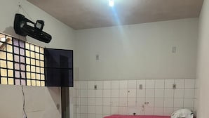 A room with three beds, a television mounted on the wall, and a ceiling light. - Pousada Hostel Formosa (Maceió)