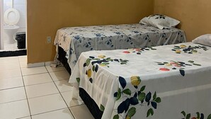 A room with two beds, a toilet, and a sink. - Pousada Hostel Formosa (Maceió)