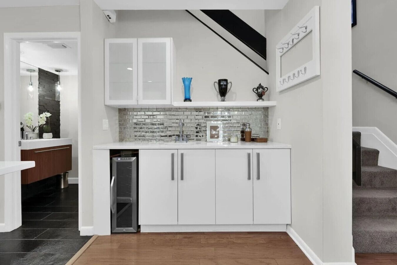 Een moderne keuken met witte kasten, een tegelwand van baksteen en een roestvrijstalen vaatwasser.