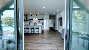 A modern kitchen with a central island, bar stools, and recessed lighting.
