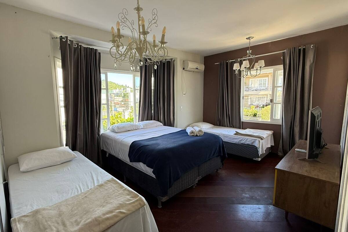 Een hotelkamer met twee bedden, een bureau, een kroonluchter en uitzicht.