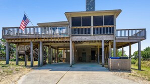 A two-story wooden structure with a balcony, a flag, and a chimney. - Borden, Ships Watch Community in Duck, NC (Duck)