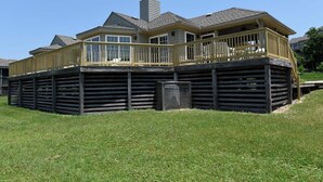 Une maison à deux étages avec un balcon et une terrasse délimitée par une clôture.