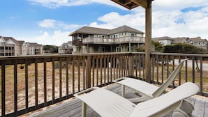 A wooden deck with two white lounge chairs, overlooking a residential area with houses and a clear sky. - Tappan, Ships Watch Community in Duck, NC (Duck)