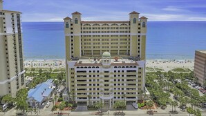 Un hôtel de grande hauteur doté d’un dôme central, de nombreux balcons et offrant une vue sur la plage.