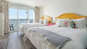 Une chambre d’hôtel avec deux lits, un balcon et vue sur la mer.
