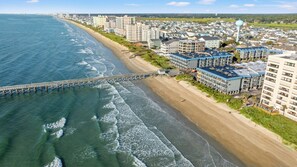 An aerial view of a coastal area with a pier, beachfront buildings, and a residential neighborhood. - Sea Cabin 120- Oceanfront 1BR/1BA- Pool (North Myrtle Beach)