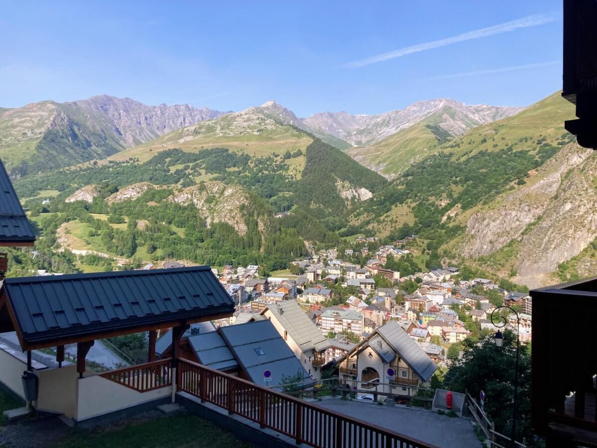 A mountainous town with a view of the valley and distant peaks.