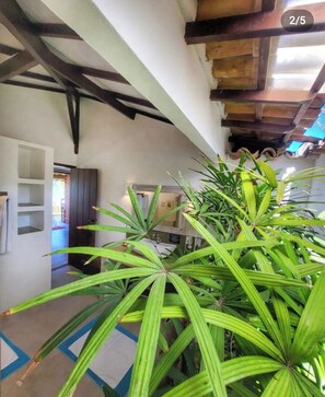 A hallway with a ceiling featuring exposed beams and a mirrored wall. - Pousada San Antônio Praia  (Porto Seguro)