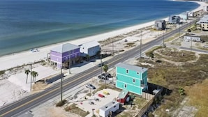 A coastal area with a beach, a road, and buildings including a two-story house and a smaller structure. - Ocean View Oasis for 8-Food Trucks @ Your Doorstep (Mexico Beach)