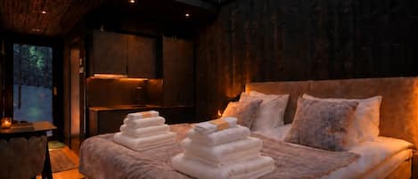 Een gezellige slaapkamer met een groot bed, een houten hoofdbord en uitzicht op de nachthemel.