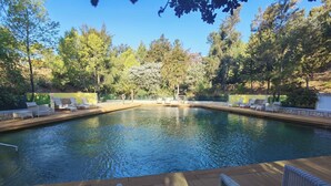 A swimming pool with lounge chairs and a wooden deck. - Apart-hotel Quinta Das Eirinhas-jardim De Bonsai (Tavira)