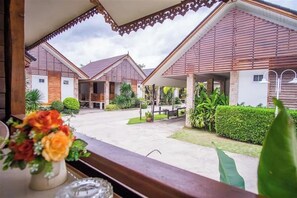 A view of a resort with multiple bungalow-style buildings, a paved courtyard, and a variety of greenery. - Ruentara Resort & Villa (Buri Ram)