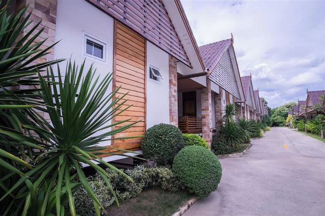 A row of modern houses with a uniform architectural style, a paved driveway, and well-maintained landscaping.