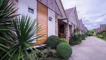 A row of modern houses with a uniform architectural style, a paved driveway, and well-maintained landscaping.