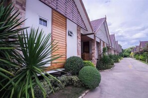 A row of modern houses with a uniform architectural style, a paved driveway, and well-maintained landscaping. - Ruentara Resort & Villa (Buri Ram)