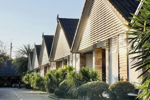 A row of motel-style buildings with pitched roofs and brick exteriors, surrounded by well-maintained landscaping. - Ruentara Resort & Villa (Buri Ram)