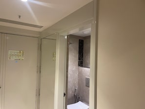 A bathroom with a shower, a mirror, and a toilet.
