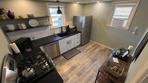 Una cucina moderna con piano cottura a gas, elettrodomestici in acciaio inossidabile e pavimento in legno.