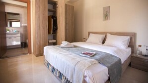 Un dormitorio con cama, mesita de noche, armario y baño con lavabo y espejo.