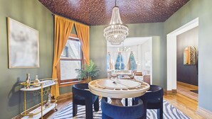 A dining area with a round table, chairs, a chandelier, and a zebra-patterned rug.