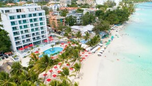 Un resort con piscina, playa y palmeras.