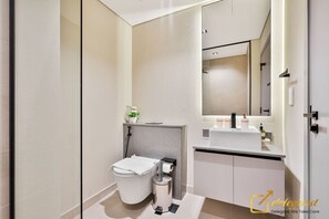 A modern bathroom with a toilet, bidet, and sink.