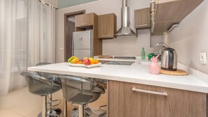 A modern kitchen with a central island, bar stools, a stainless steel range hood, and a refrigerator. - Sirene 1-BR Apt Pool & Gym in Gemmayze (Beirut)