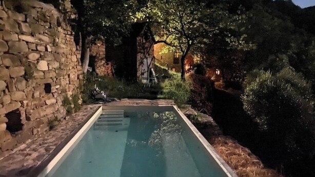 Piscina com paredes de pedra e ambiente rústico.