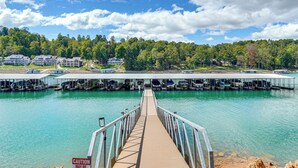 A pier leading to a dock with boats, a caution sign, and a backdrop of houses and trees. - Private Boat Slip, Scenic Views: Norris Lake Condo (Morley)