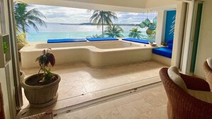 Ein Balkon mit Blick auf den Ozean, einem Whirlpool und Topfpflanzen.