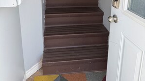 A staircase leading to a door with a glass panel and a doorbell. - 3 Bed 2.5 bath on Queen pet friendly (St. John's)