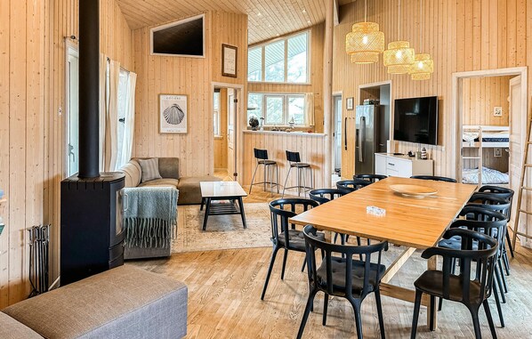 A cozy cabin interior with a dining area, kitchen, and seating space.