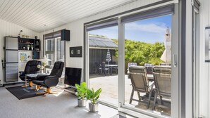 A modern living room with a large sliding glass door leading to an outdoor patio area.