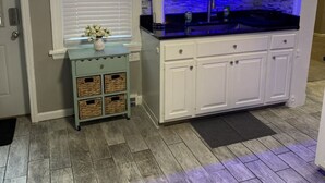 A kitchen with white cabinets, a black countertop, and a blue-lit backsplash. - Perfect for Families, newly remodeled (Glendale)