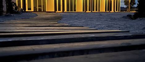 Un edifici modern amb diverses portes il·luminades i una zona exterior coberta decorada amb llums de garlandes.