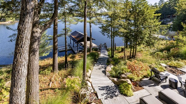 Una terrazza sul lago con posti a sedere all'aperto e una zona riparata con vista sull'acqua.