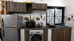 Cocina compacta con refrigerador, microondas y lavadora.