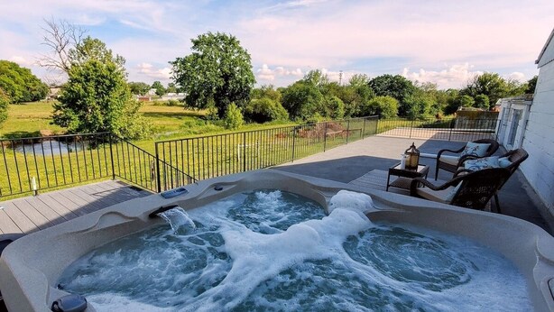 A hot tub on a deck with a view of a grassy area and trees. - Amish Cottage, Hot Tub, on Mill Creek (Lancaster)