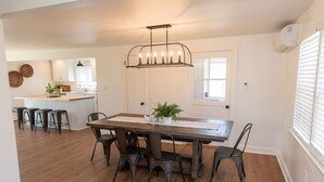 A dining area with a wooden table, six chairs, and a pendant light. - Amish Cottage, Hot Tub, on Mill Creek (Lancaster)