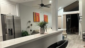 Una cocina moderna con una isla central, electrodomésticos de acero inoxidable y un ventilador de techo.