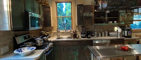 A modern kitchen with a skylight, stainless steel appliances, and a large window.