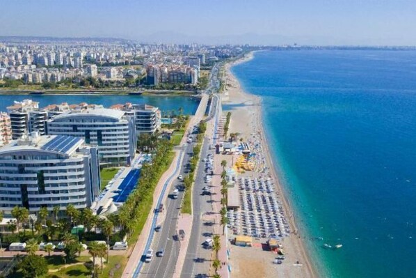 Eine Küstenstadt mit Strand, Gebäuden und einer Straße.