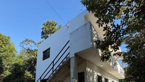 A two-story building with a staircase leading to the upper floor. - Apartamento #3 (Macario Gómez)