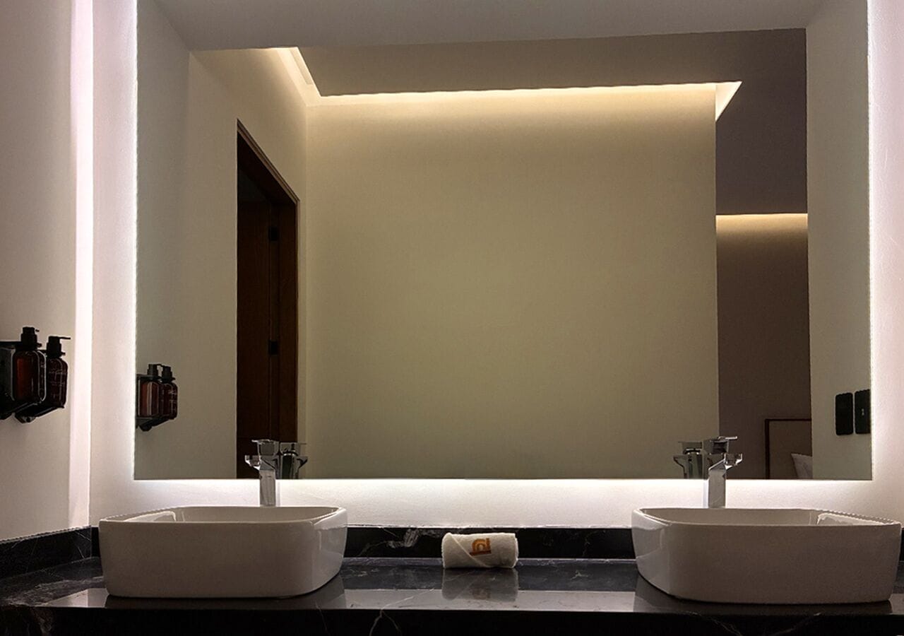 A modern bathroom with two sinks, a large mirror, and a towel on the counter.