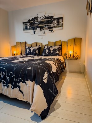 Een slaapkamer met een groot bed, een houten hoofdeinde en een wereldkaart aan de muur.