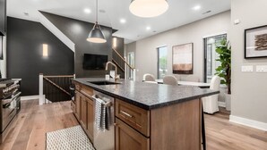 A modern kitchen with a central island, wooden cabinets, and pendant lighting. - Just Listed, D Town Views, OSU, Short North! (Columbus)